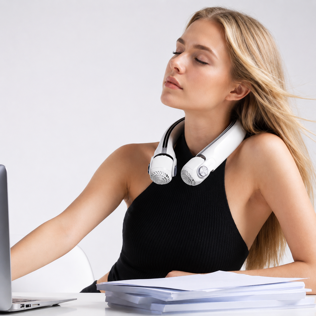 Blonde woman wearing a white directional rotor neck fan, eyes closed, enjoying the cooling breeze.