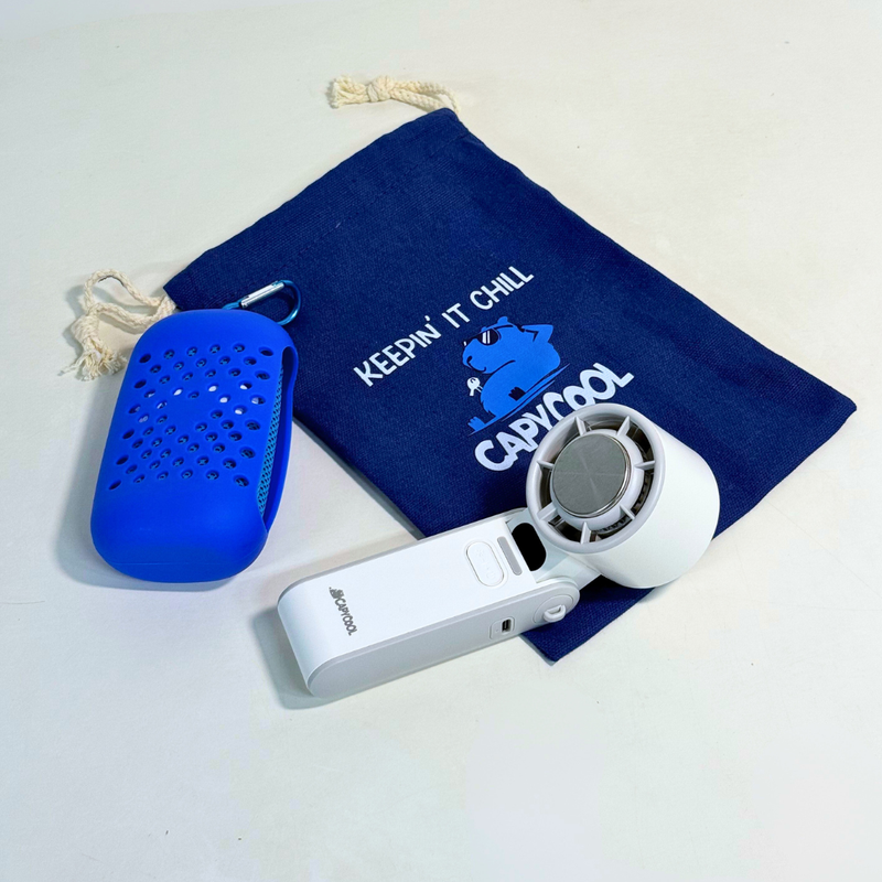 Navy blue Capycool drawstring pouch with "Keepin' It Chill" logo, a white portable fan, and a blue cooling towel.