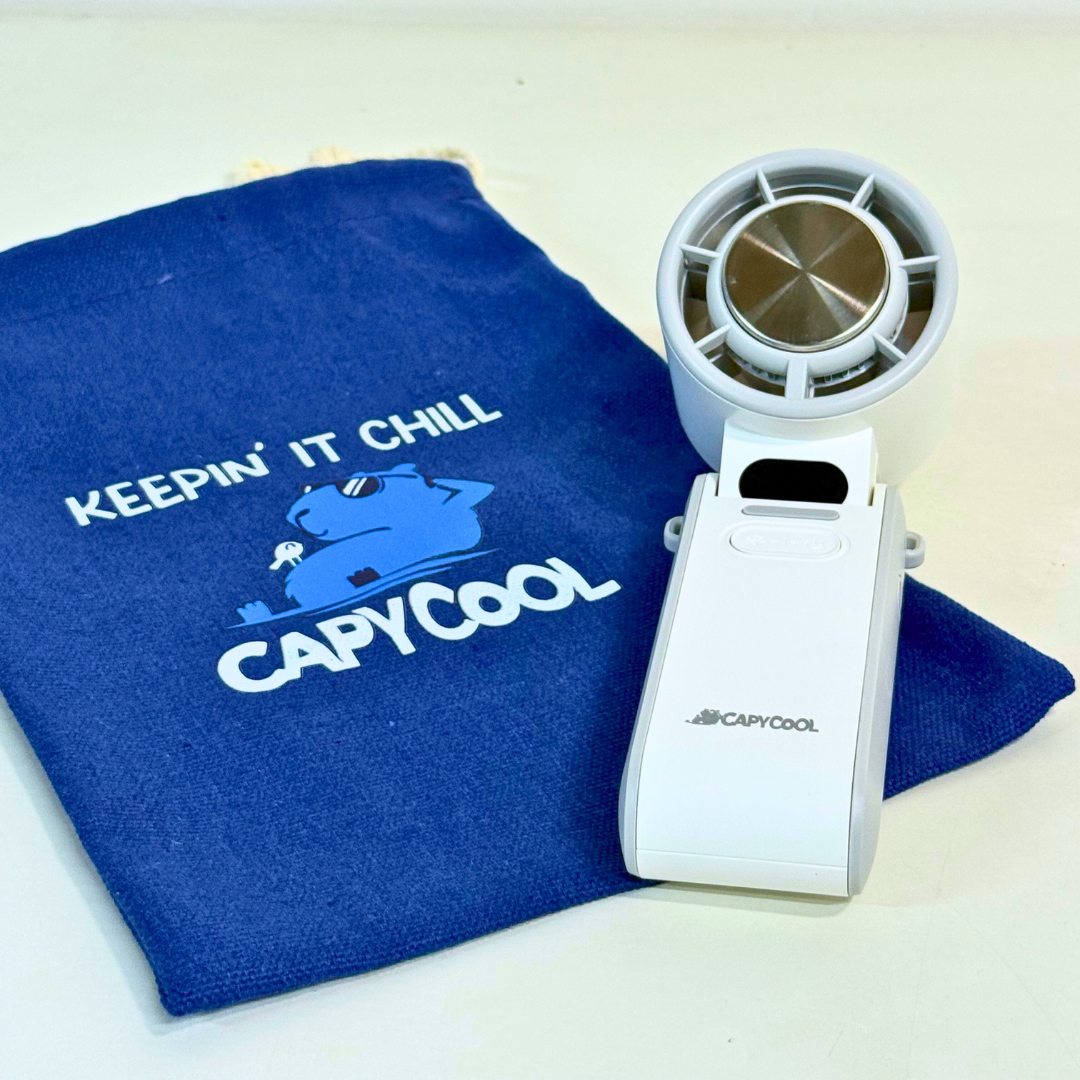 Blue drawstring pouch with "Keepin' It Chill CapyCool" logo next to a white CapyCool waist fan.